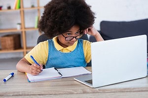 elearning girl at laptop with notebook